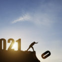 Man push number zero down the cliff where has the number 2021 with blue sky and sunrise. It is symbol of starting and welcome happy new year 2021.