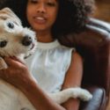 Woman laying on couch petting dog