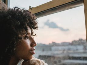 woman and dog looking out window