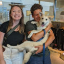 adoption celebration photo, man holding dog in his arms and lady smiling next to them