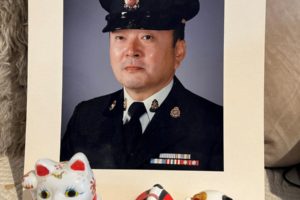 A portrait of James Ito with maneki-neko (beckoning cat) a Japanese figurine which is believed to bring good luck to the owner.